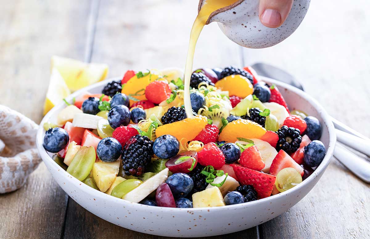 summer fruit salad in a bowl with dressing