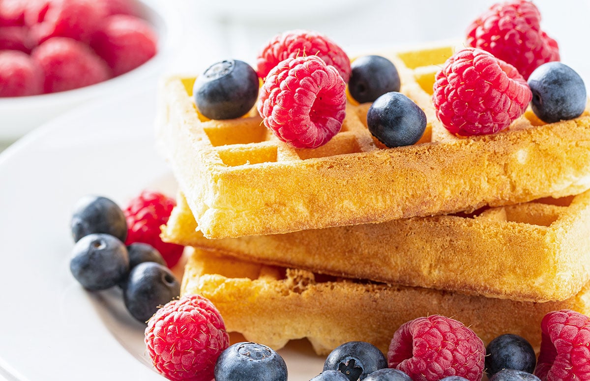 stack of three ricotta pancakes topped with berries