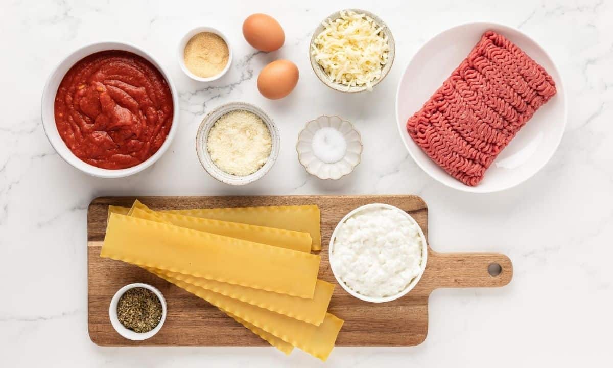 ingredients to make cottage cheese lasagna: marinara sauce, eggs, cheese, lasagna noodles, cottage cheese, ground meat and seasonings