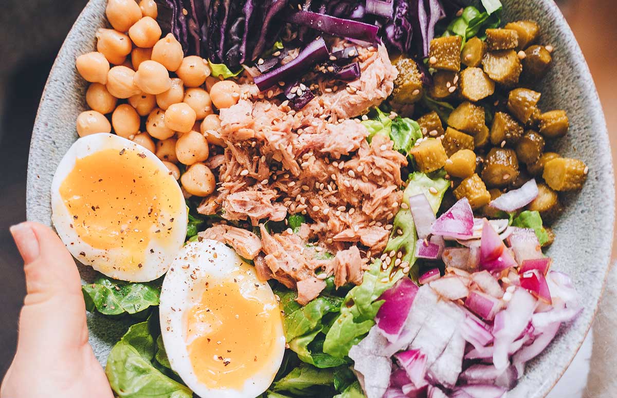 top view of a protein sald with tuna, eggs, chickpeas and veggies