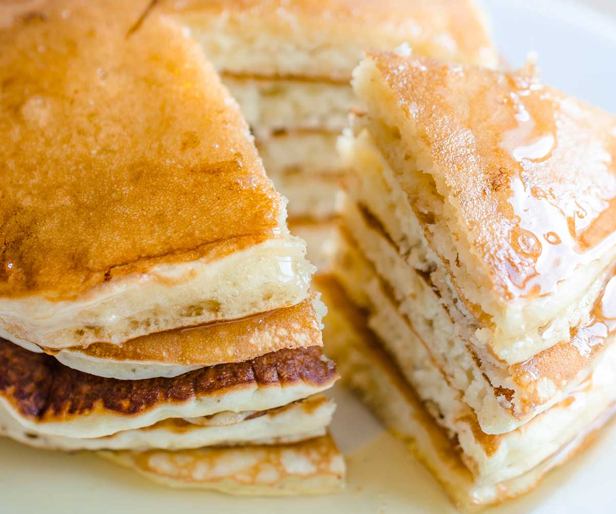 stack of pancakes made with Bisquick cut to show the fluffy texture on a plate