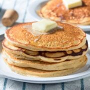stack of buttermilk pancakes made using a mix on a plate with a pat of butter on top