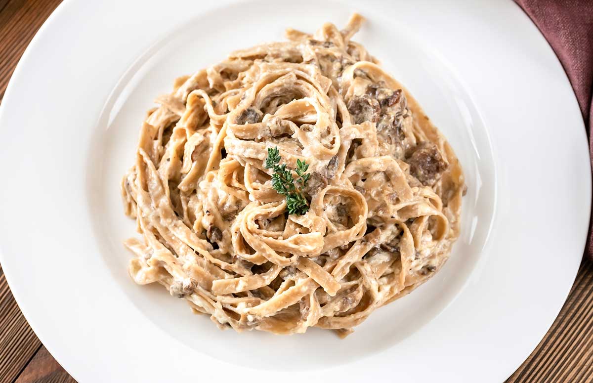 top view of mushroom alfredo pasta in a white dish