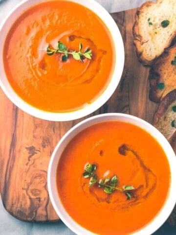 two bowls of creamy tomato soup