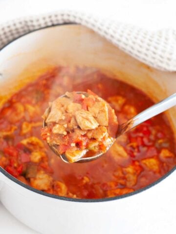 chicken goulash in a pot and a spoonful of this stew