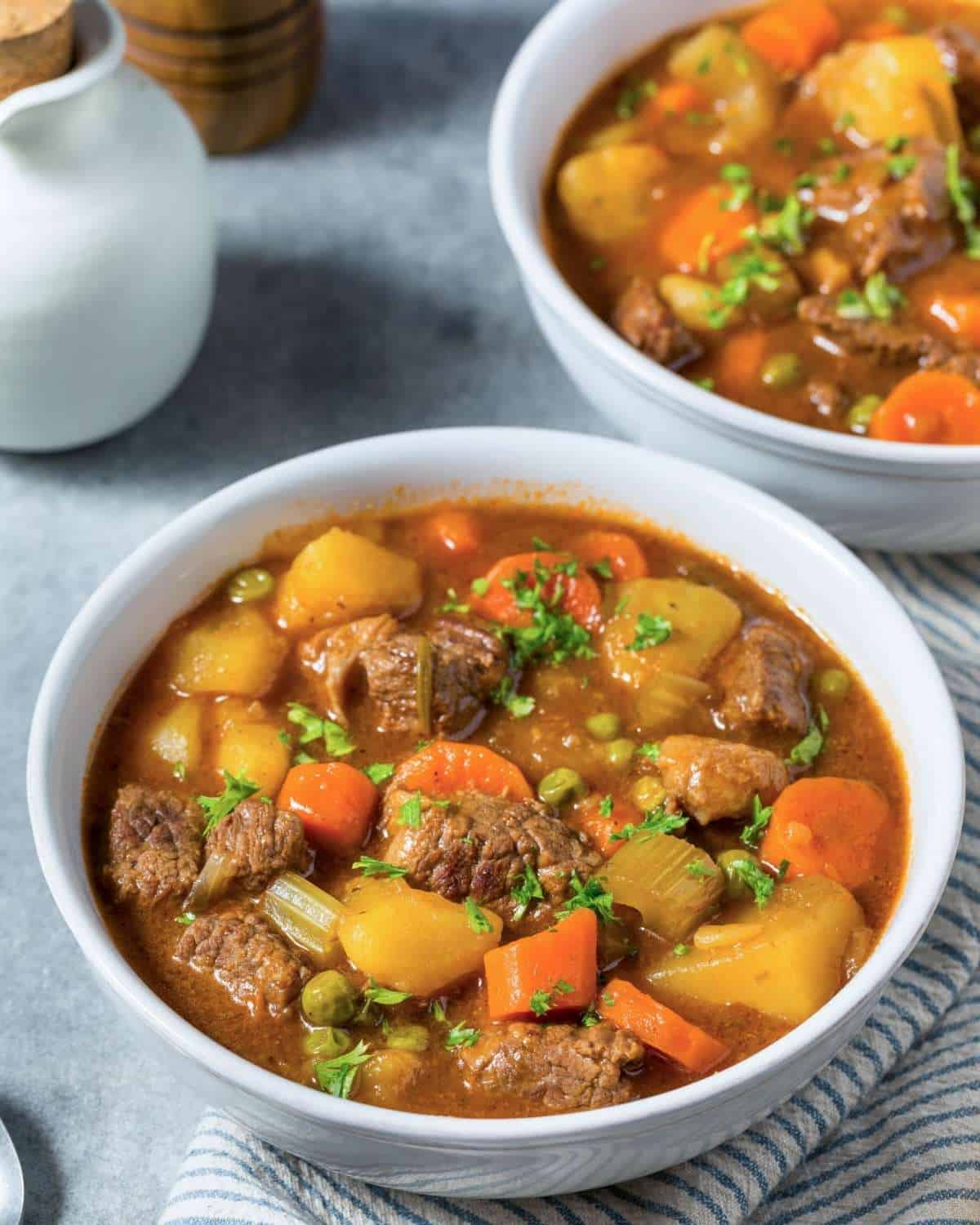 two bowls of beef stew with potatoes and carrots