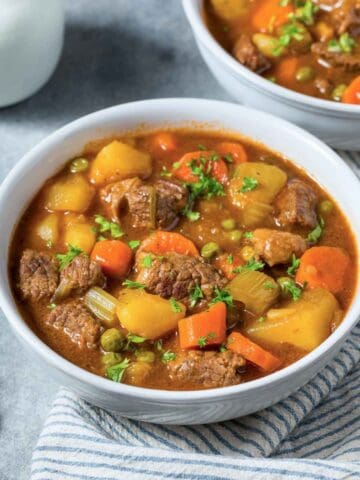 two bowls of beef stew with potatoes and carrots