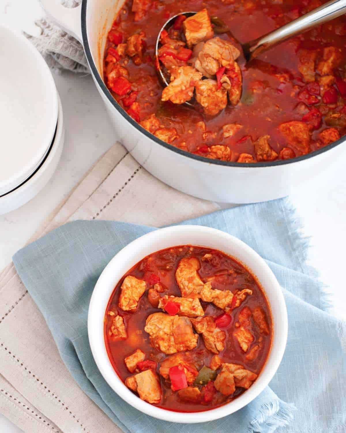 a pot with chicken goulash and a serving in a bowl on the side