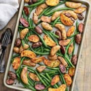 overhead view of roasted potatoes and green beans in a baking sheet