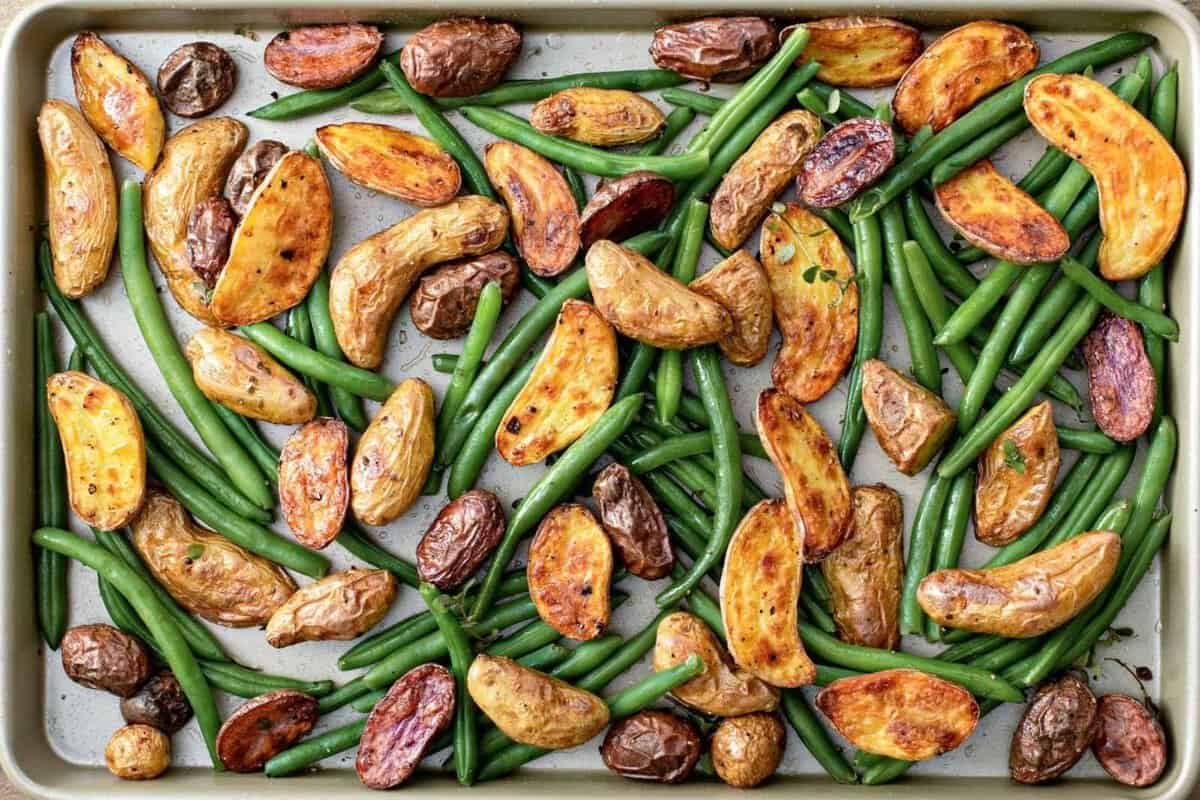 overhead view of roasted potatoes and green beans in a baking sheet