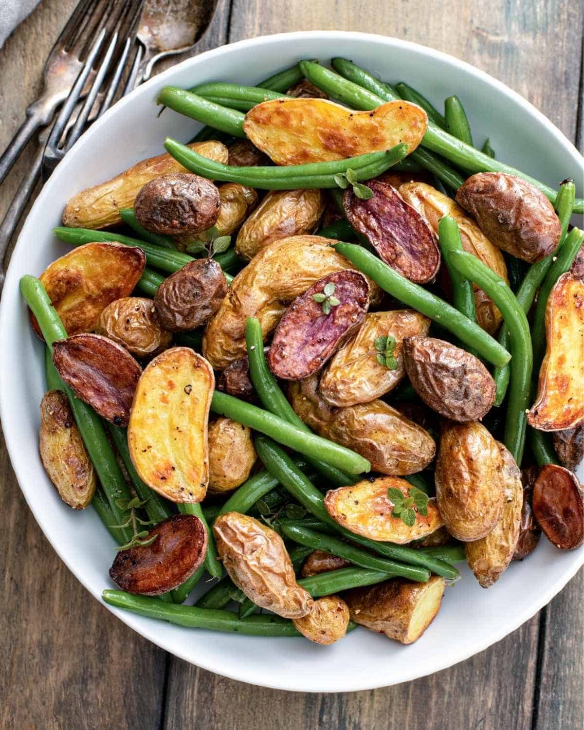 overhead view of roasted potatoes and green beans in a plate