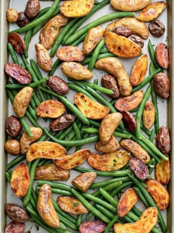 overhead view of roasted potatoes and green beans in a baking sheet
