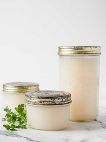 three jars with homemade chicken broth