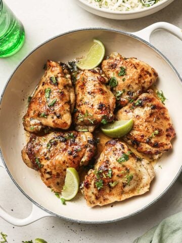 top view of six cilantro lime chicken thighs in a white dish