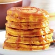 stack of fluffy pumpkin ricotta pancakes with syrup on top on a plate