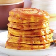 stack of fluffy pumpkin ricotta pancakes with syrup on top on a plate
