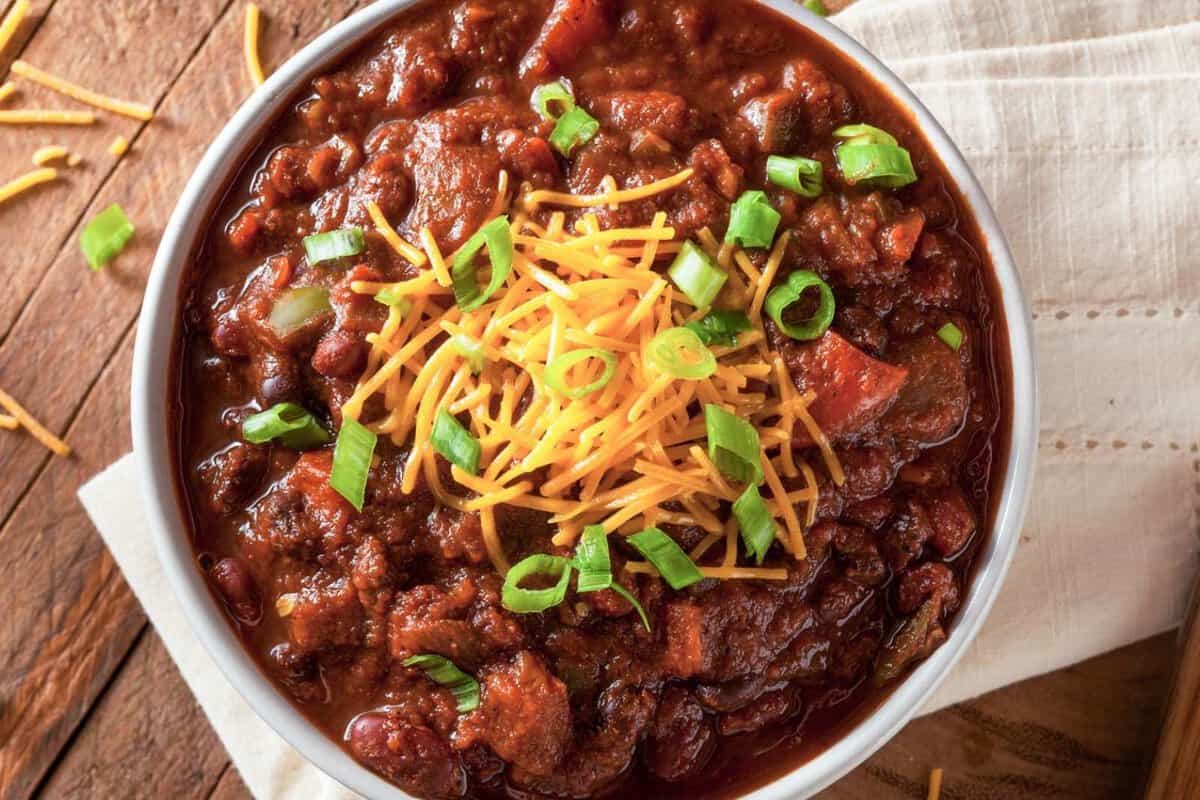 overhead view of beef chili topped with cheese and chives