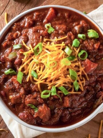 overhead view of beef chili topped with cheese and chives