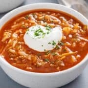 a bowl of cabbage tomato soup topped with sour cream