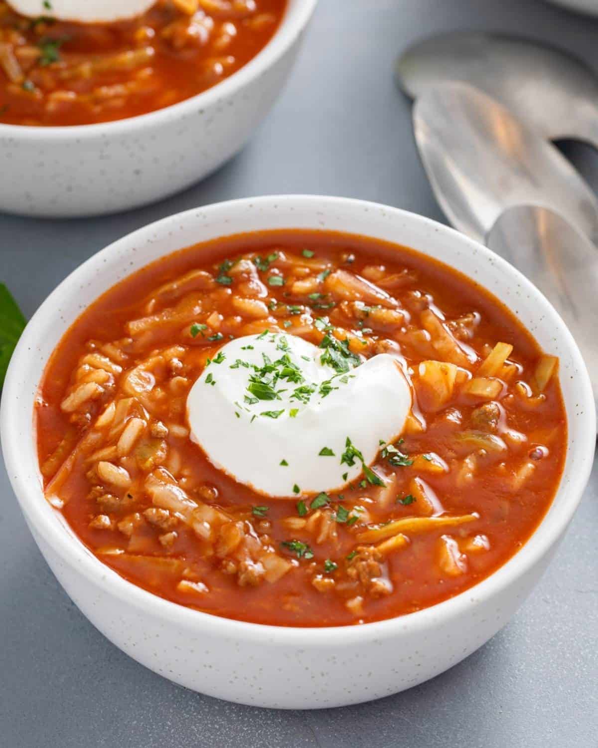 a bowl of cabbage tomato soup topped with sour cream
