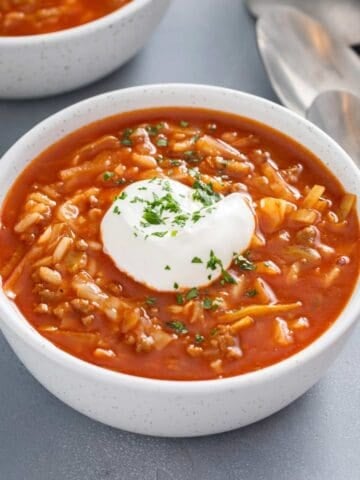 a bowl of cabbage tomato soup topped with sour cream