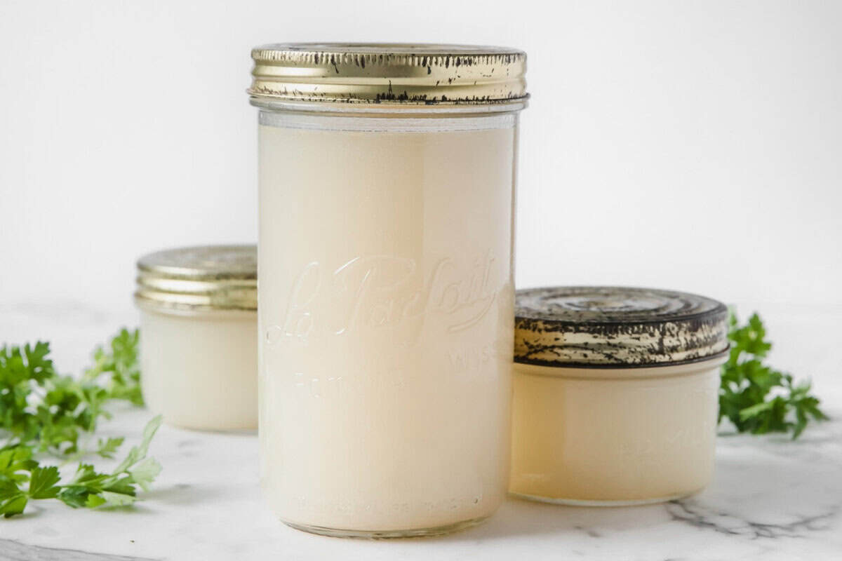 two small jars and a large one filled with chicken broth