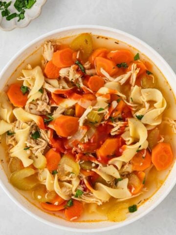 a bowl filled with spicy chicken noodle soup