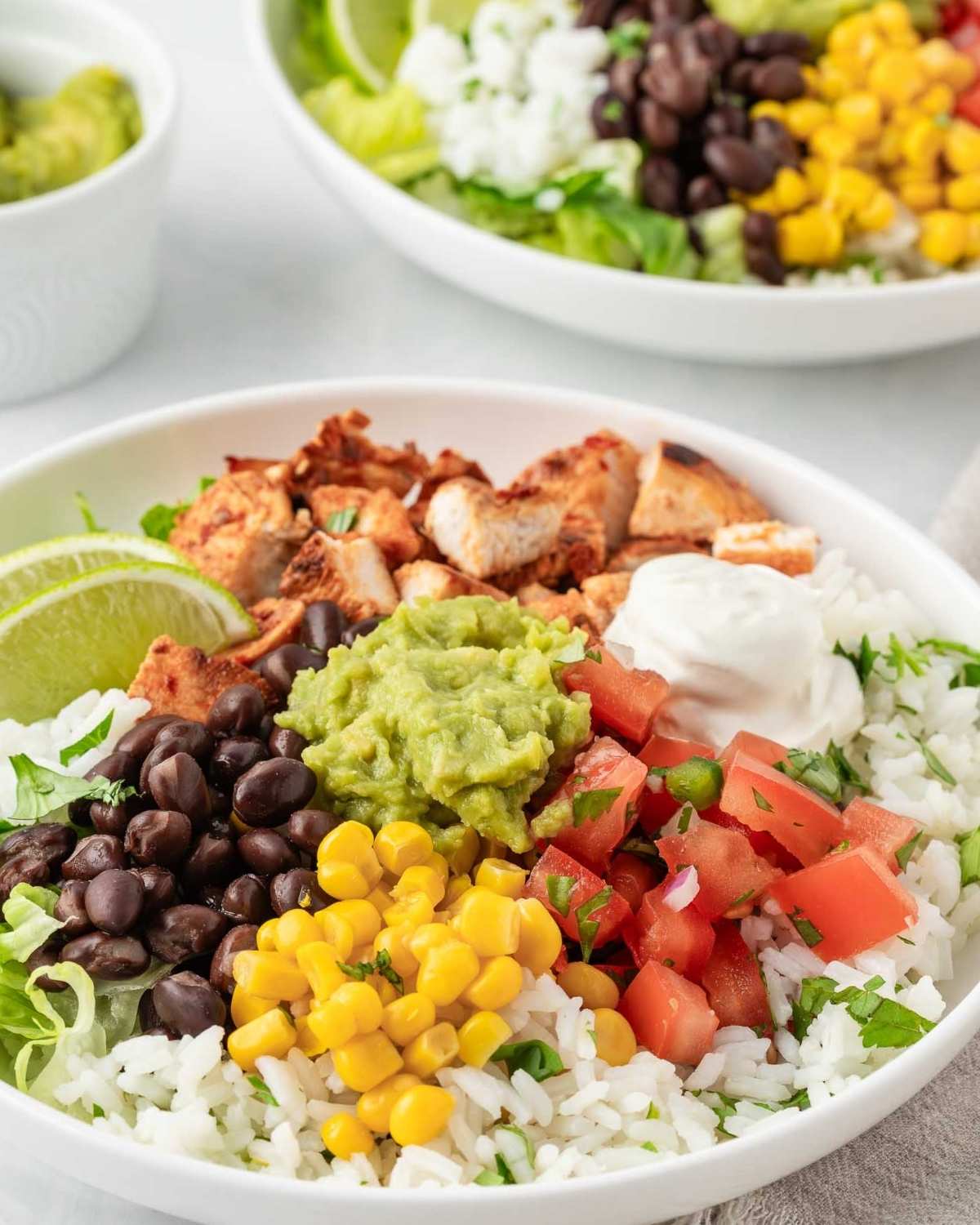 two chipotle chicken burrito bowls with lots of burrito toppings