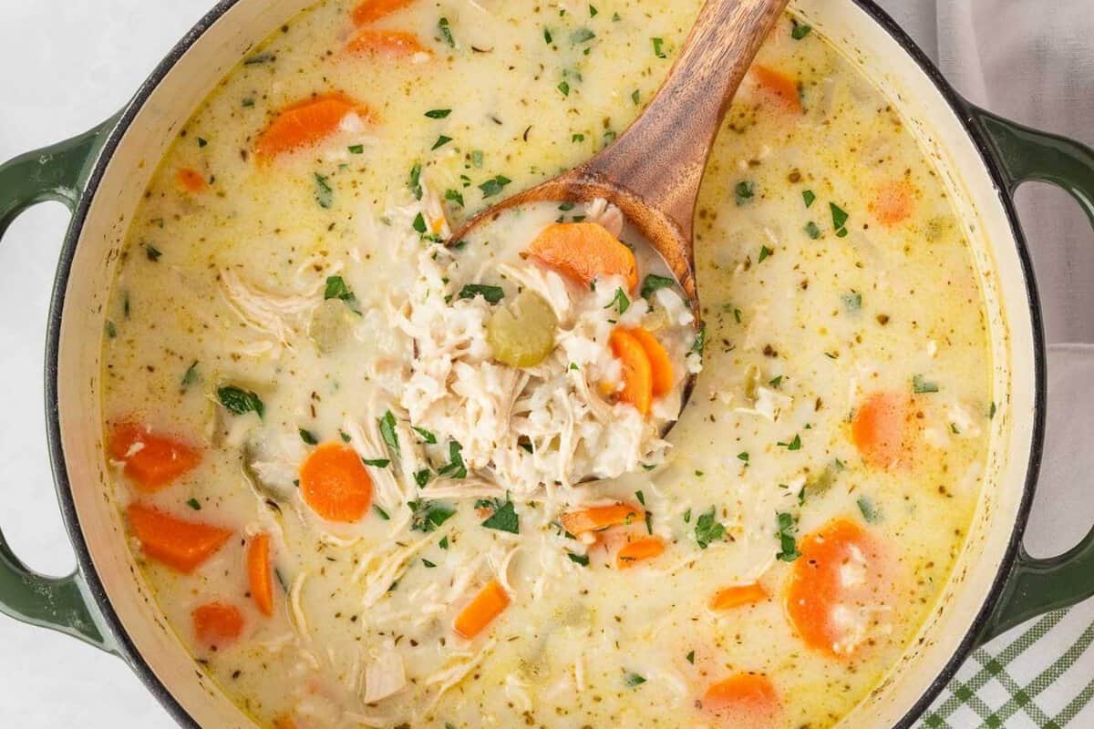 laddling creamy chicken and rice soup out of a pot