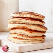 fluffy stack of sour cream pancakes stacked on a wooden board