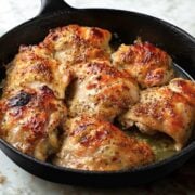 seven honey mustard chicken thighs in a cast iron skillet