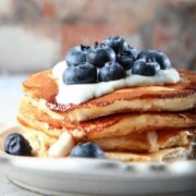 stack of ricotta pancakes topped with blueberries and yogurt