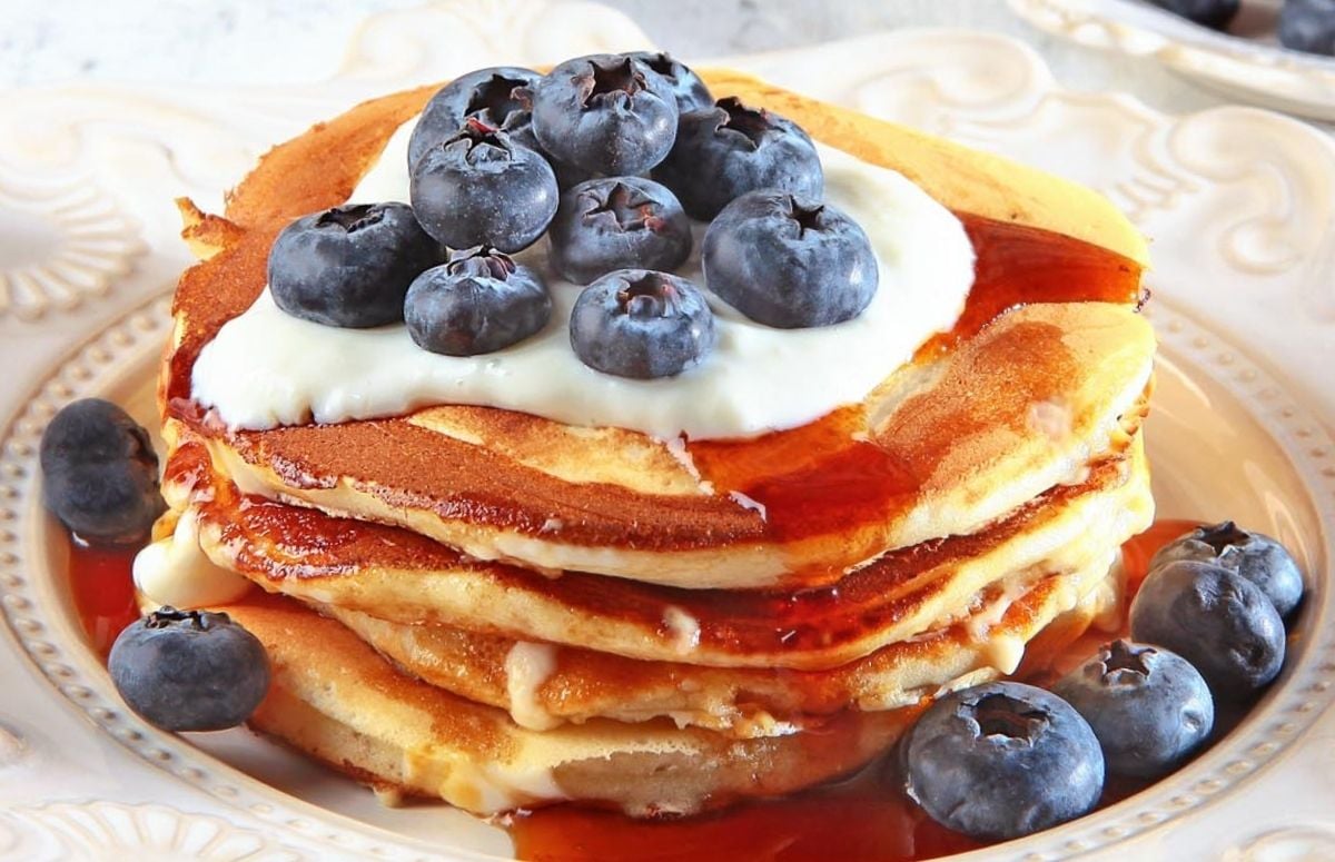 stack of ricotta pancakes topped with blueberries and yogurt