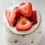 a jar of overnight oats topped with sliced strawberries
