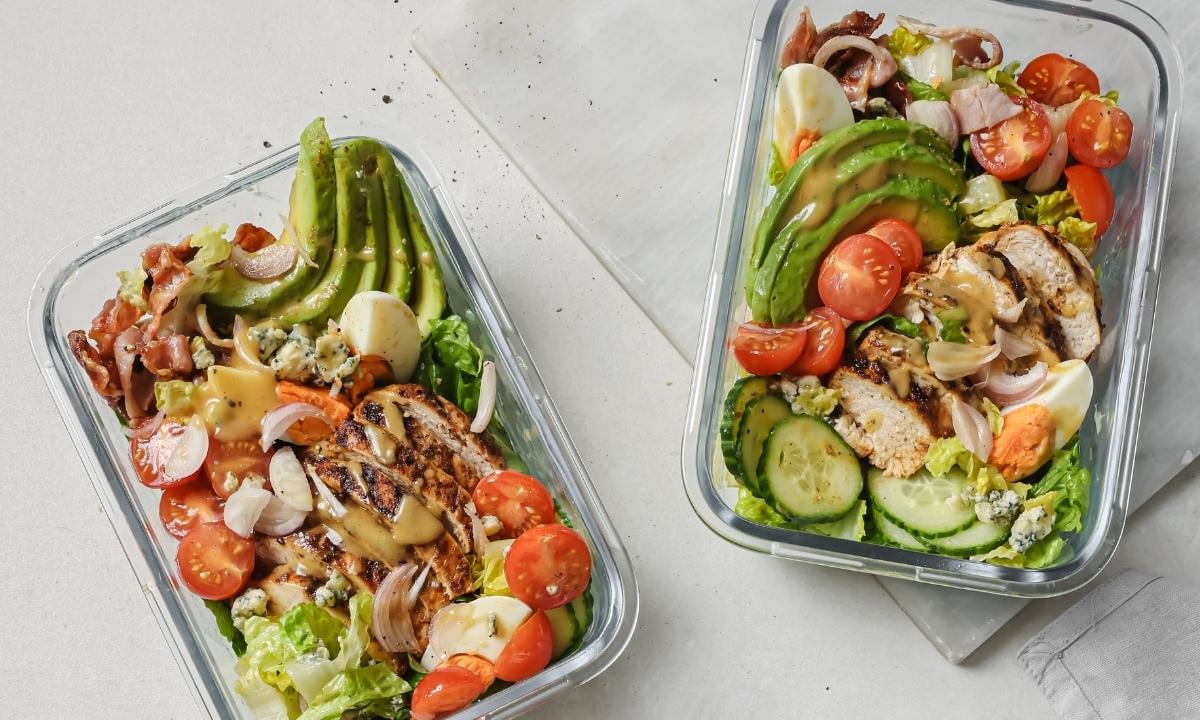 top view of two glass lunch containers with cobb salad