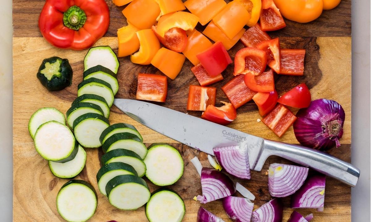 Veggies chopped to make kabobs. Chopped bell peppers, zucchini, and onions on a board. 
