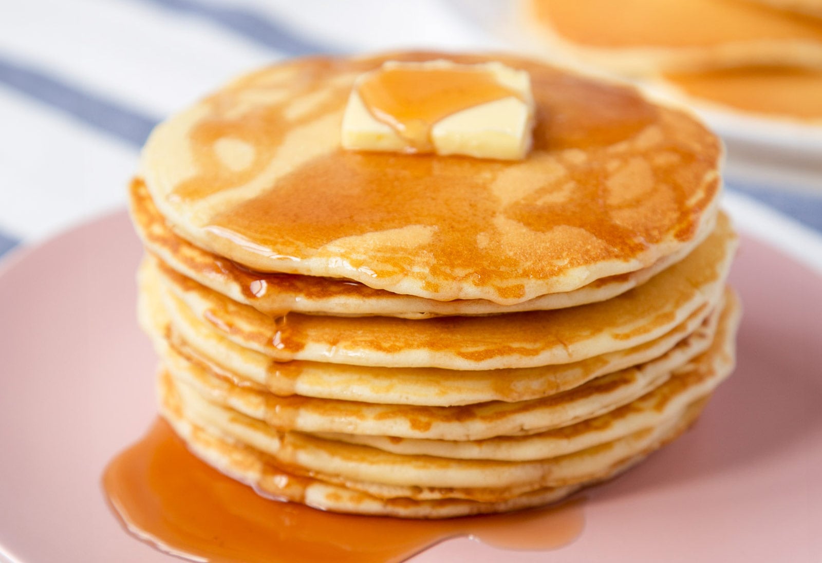 stack of homemade mcdonald's pancakes on a plate topped with a pat of butter and syrup over the top