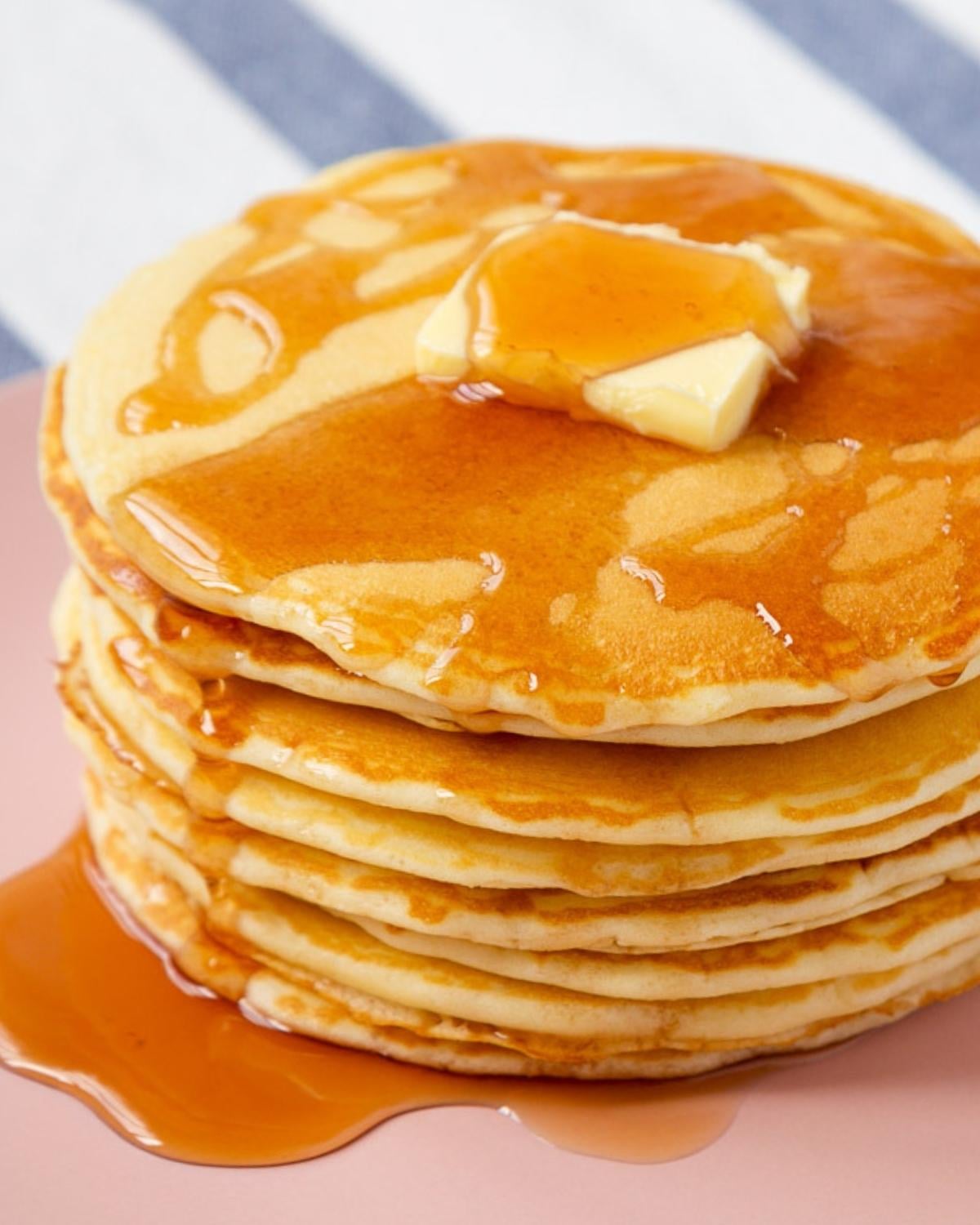 stack of homemade mcdonald's pancakes on a plate topped with a pat of butter and syrup over the top