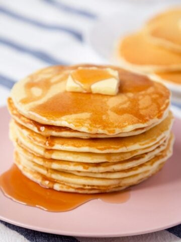 stack of homemade mcdonald's pancakes on a plate topped with a pat of butter and syrup over the top