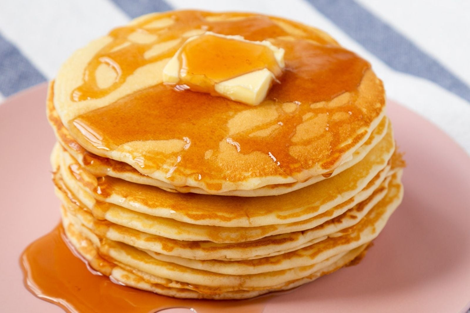 stack of homemade mcdonald's pancakes on a plate topped with a pat of butter and syrup over the top