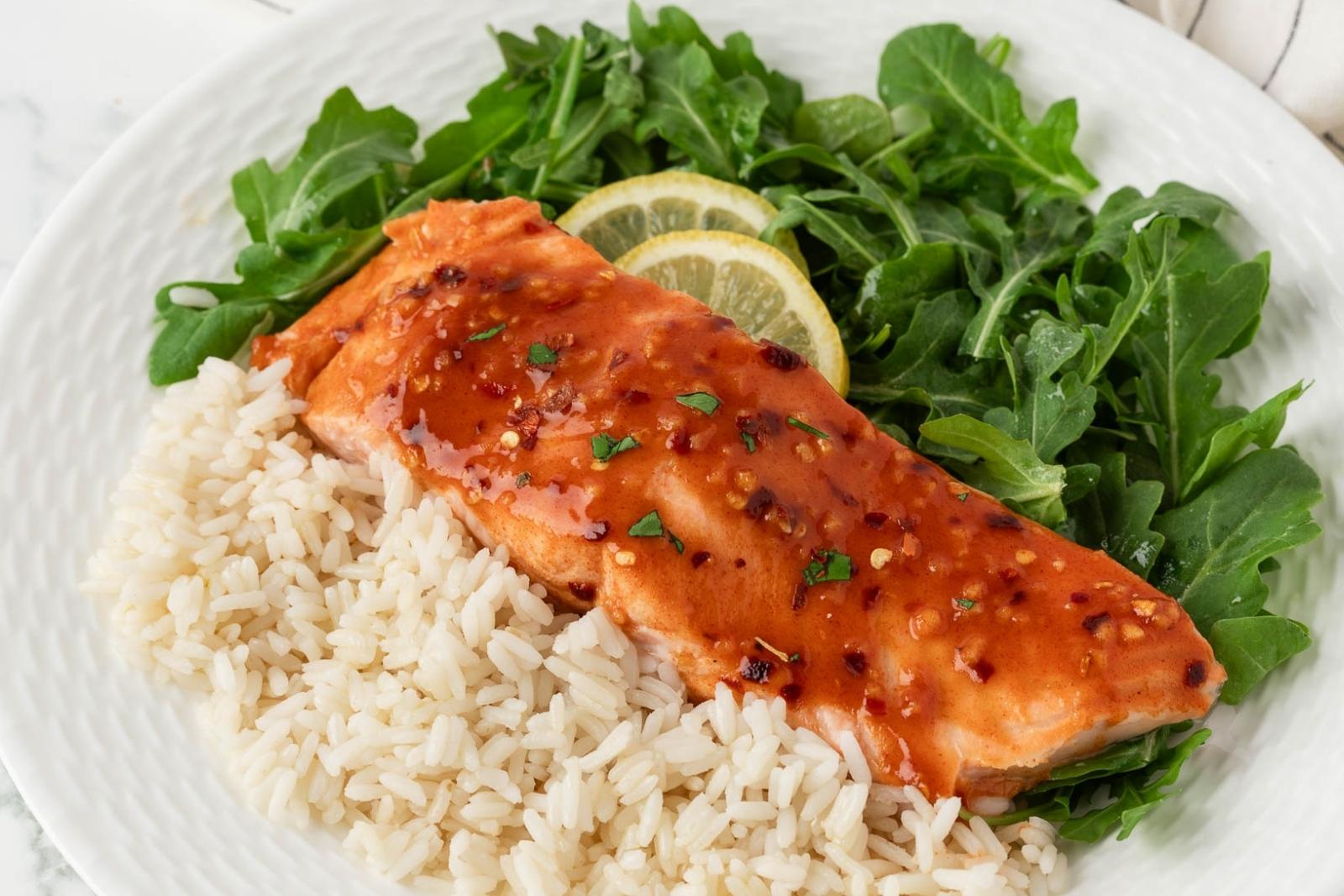 a dish with hot honey salmon, white rice, and greens