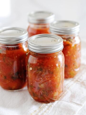 4 pint jars filled with homemade canned salsa