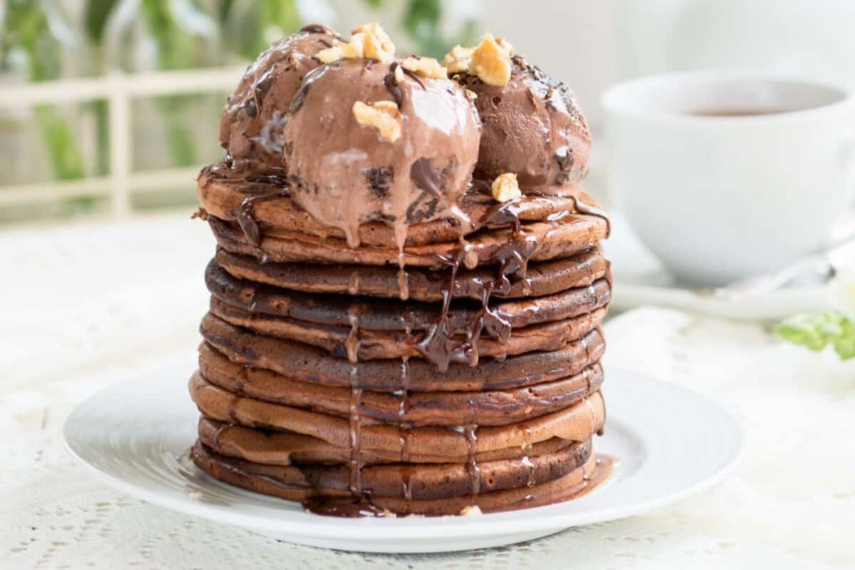 a stack of chocolate pancakes topped with chocolate ice cream
