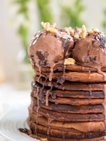 a stack of chocolate pancakes topped with chocolate ice cream
