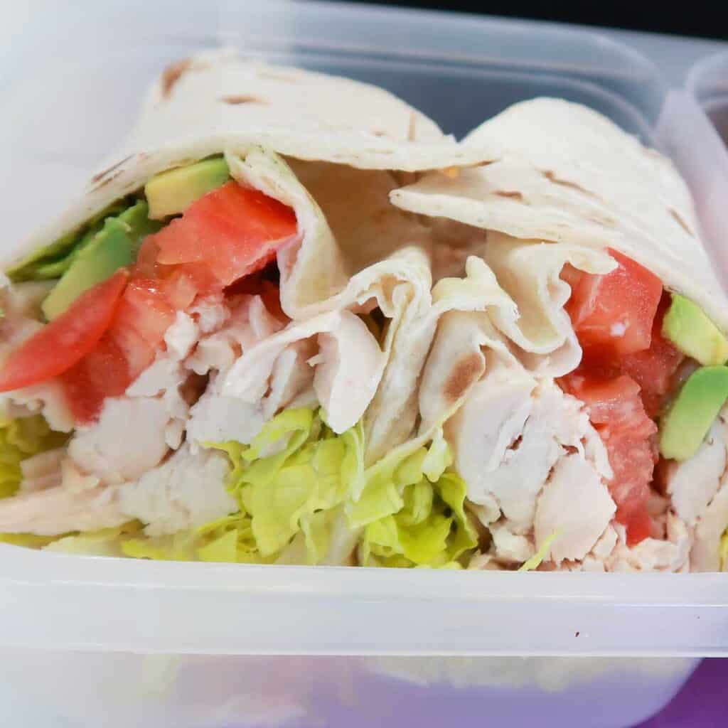 chicken avocado wrap sliced in halves in a lunchbox