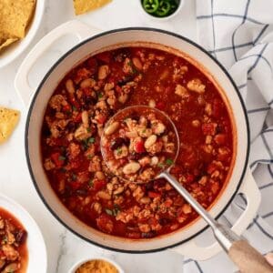 ladling out ground chicken chili out of a pot