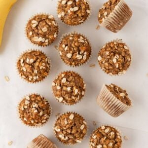 overhead view of healthy banana oatmeal muffins on the counter next to bananas