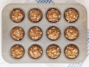 overhead view of banana oat muffins in a muffin pan after they're baked