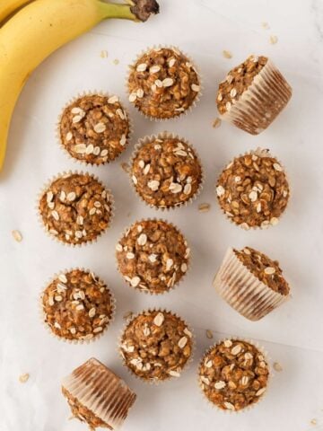 overhead view of healthy banana oatmeal muffins on the counter next to bananas