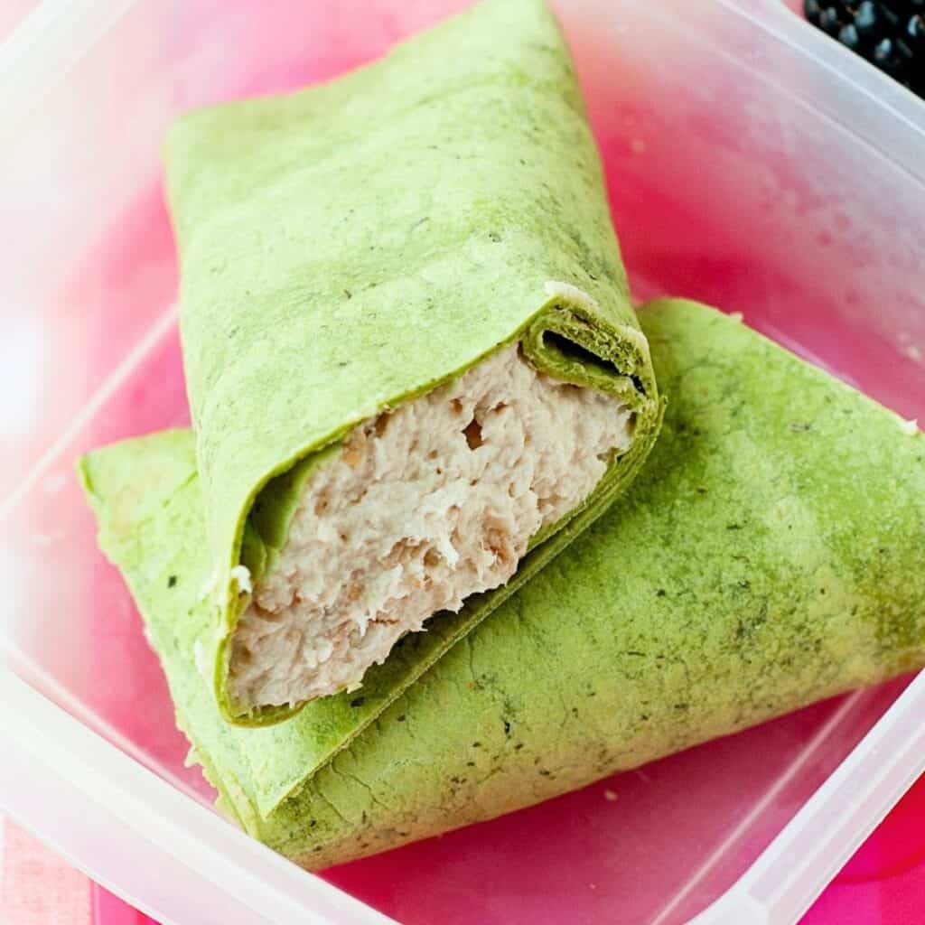 chicken wrap sliced in halves in a lunchbox